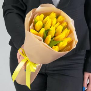 Букет из 19 желтых тюльпанов в крафтовой бумаге